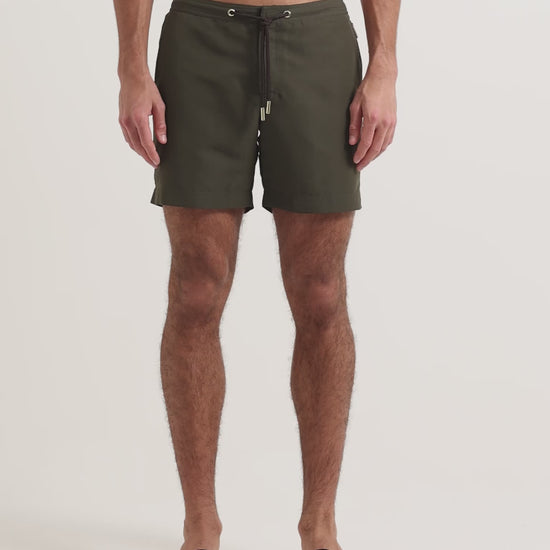 Model wearing dark green drawcord swim shirts with brown leather sandals