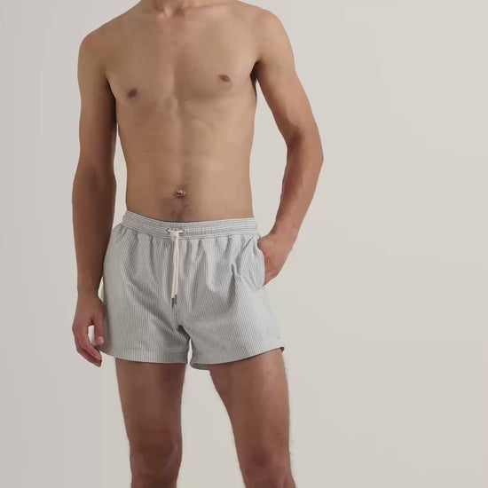 Man wearing grey seersucker swim short with drawstring waistband 