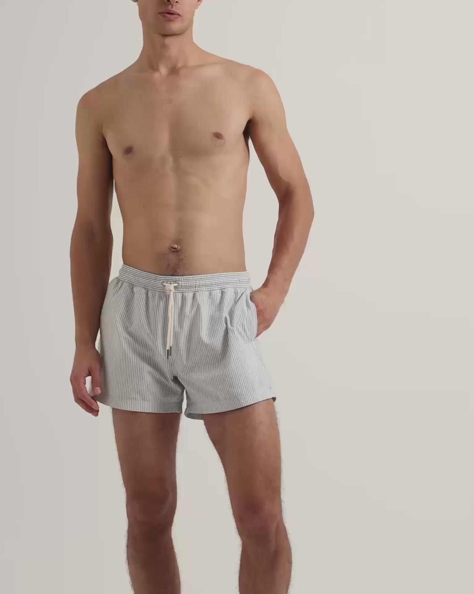 Man wearing grey seersucker swim short with drawstring waistband 