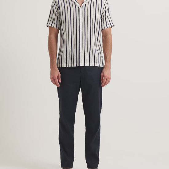 Man wearing striped short sleeve shirt with navy trousers