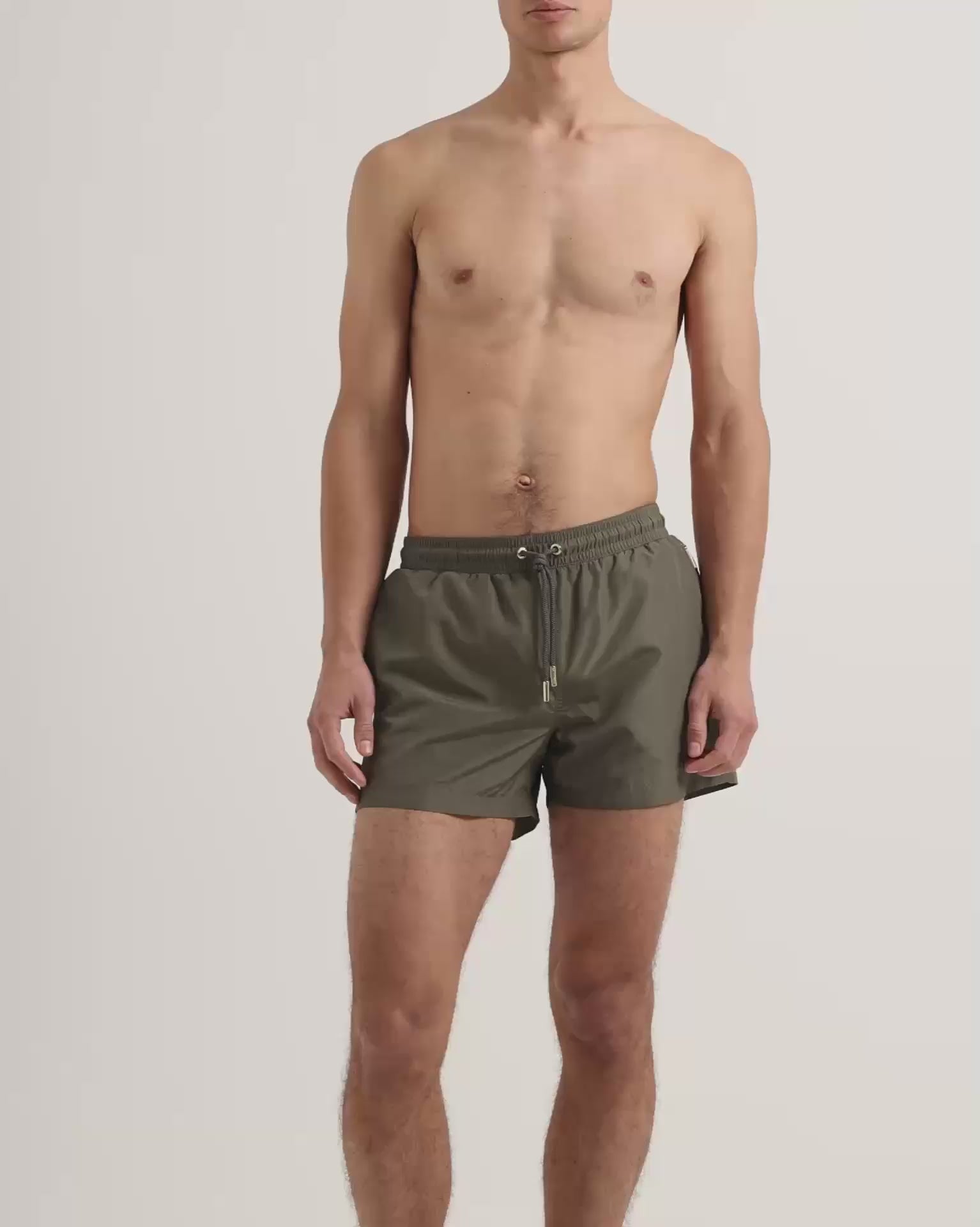 Man wearing dark green swim shorts with drawstring waist