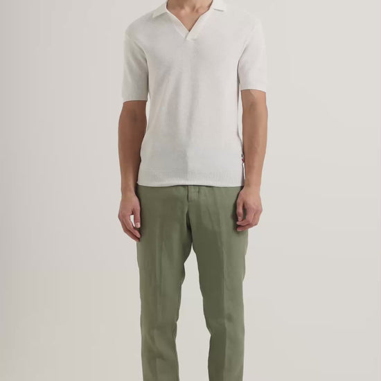 Man wearing white polo shirt with green linen trousers