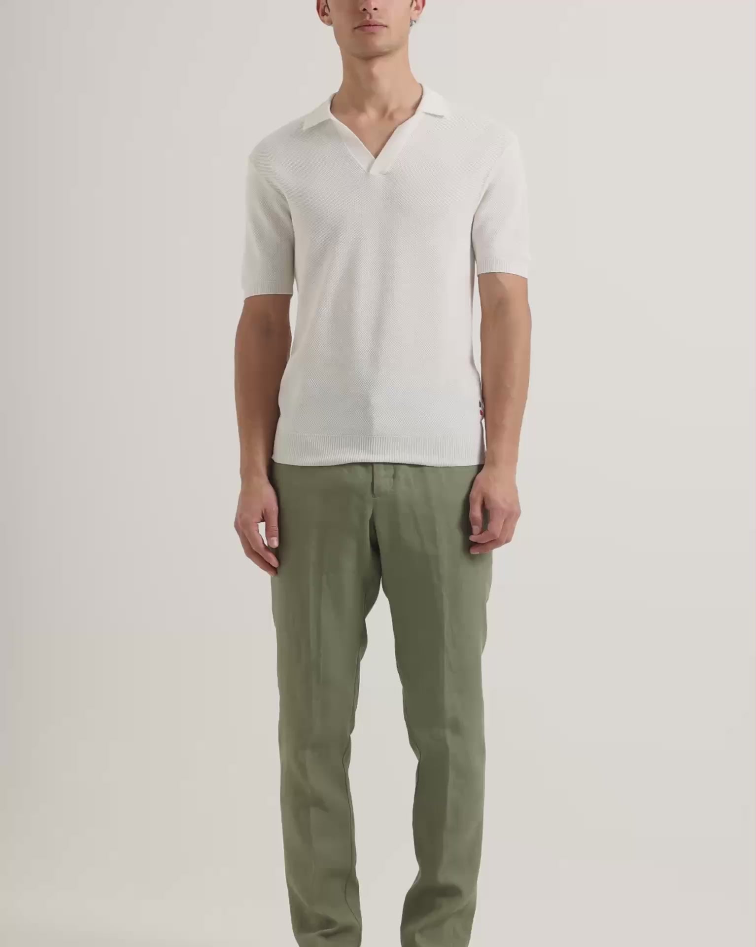 Man wearing white polo shirt with green linen trousers