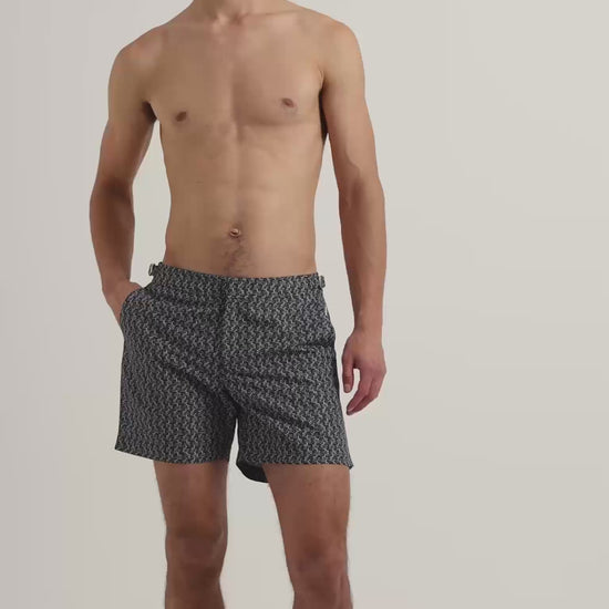 Man wearing dark navy patterned swim shorts with brown leather sandals