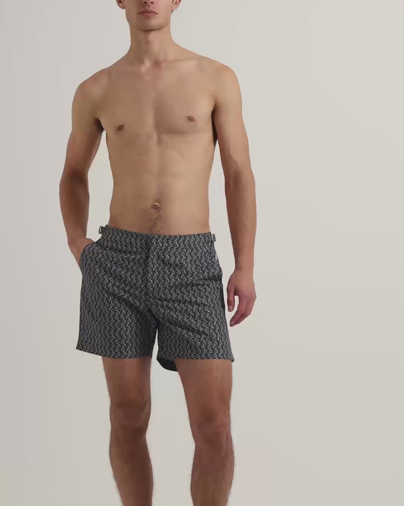 Man wearing dark navy patterned swim shorts with brown leather sandals