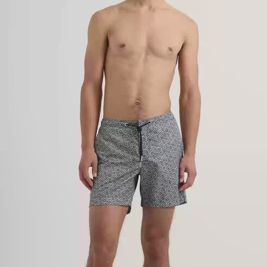 Man wearing dark navy patterned swim shorts with drawstring waist