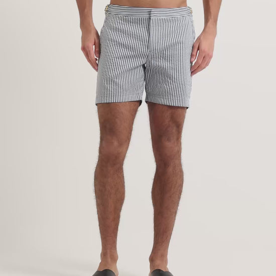 Man wearing blue and white striped swim shorts with brown leather sandals