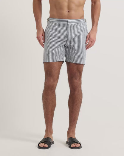 Man wearing blue and white striped swim shorts with brown leather sandals