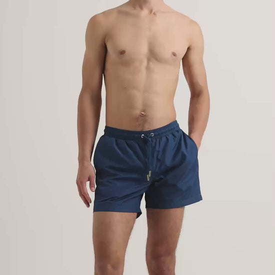 Man wearing dark navy swim shorts with drawstring waist
