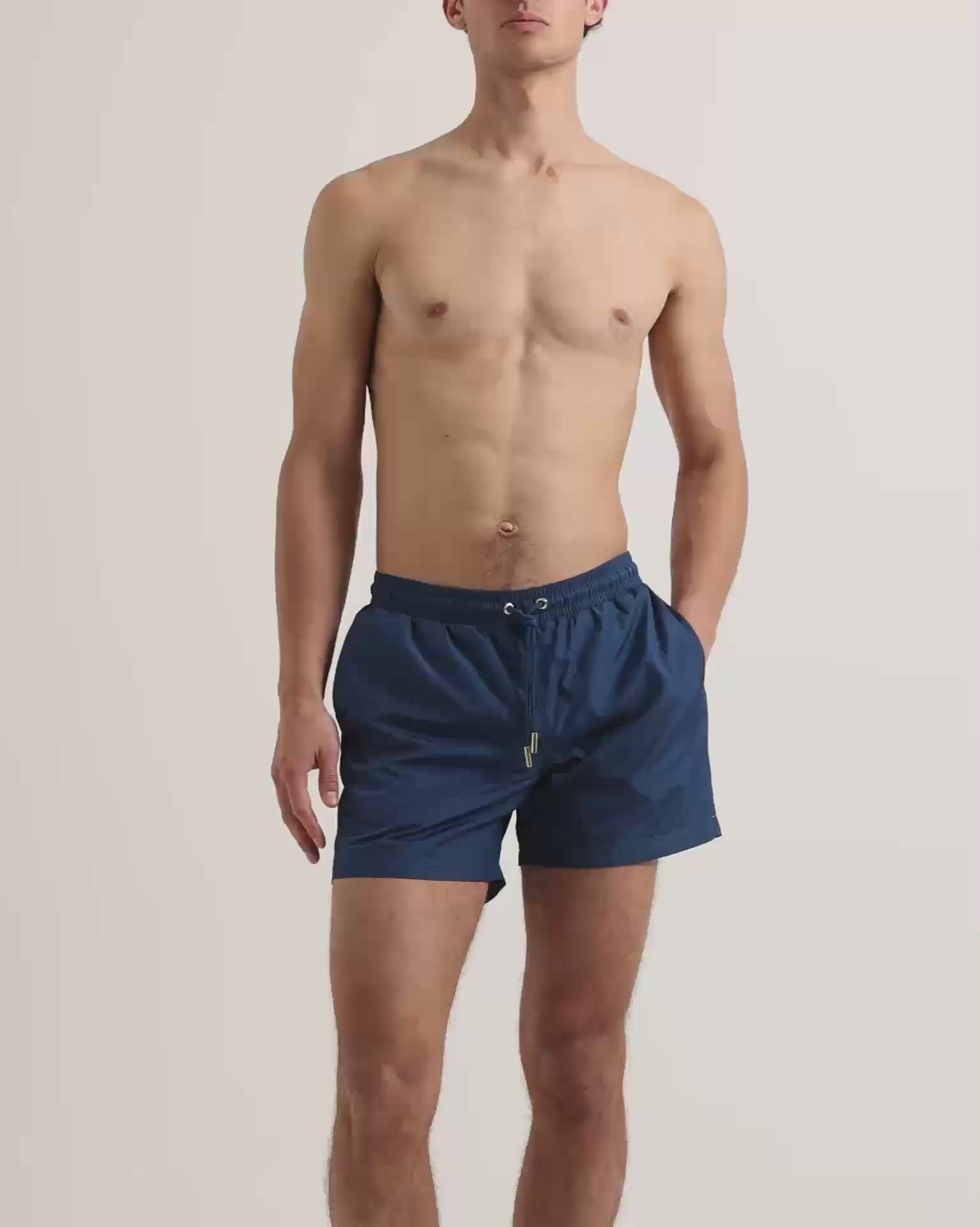 Man wearing dark navy swim shorts with drawstring waist