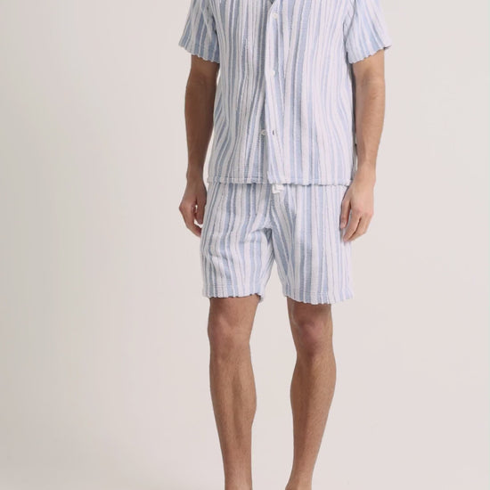 Man wearing blue striped towelling set on a white background