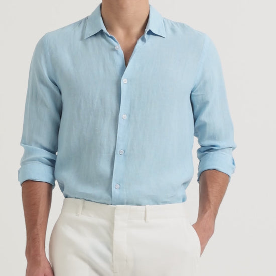 Man wearing light blue linen shirt with white trousers