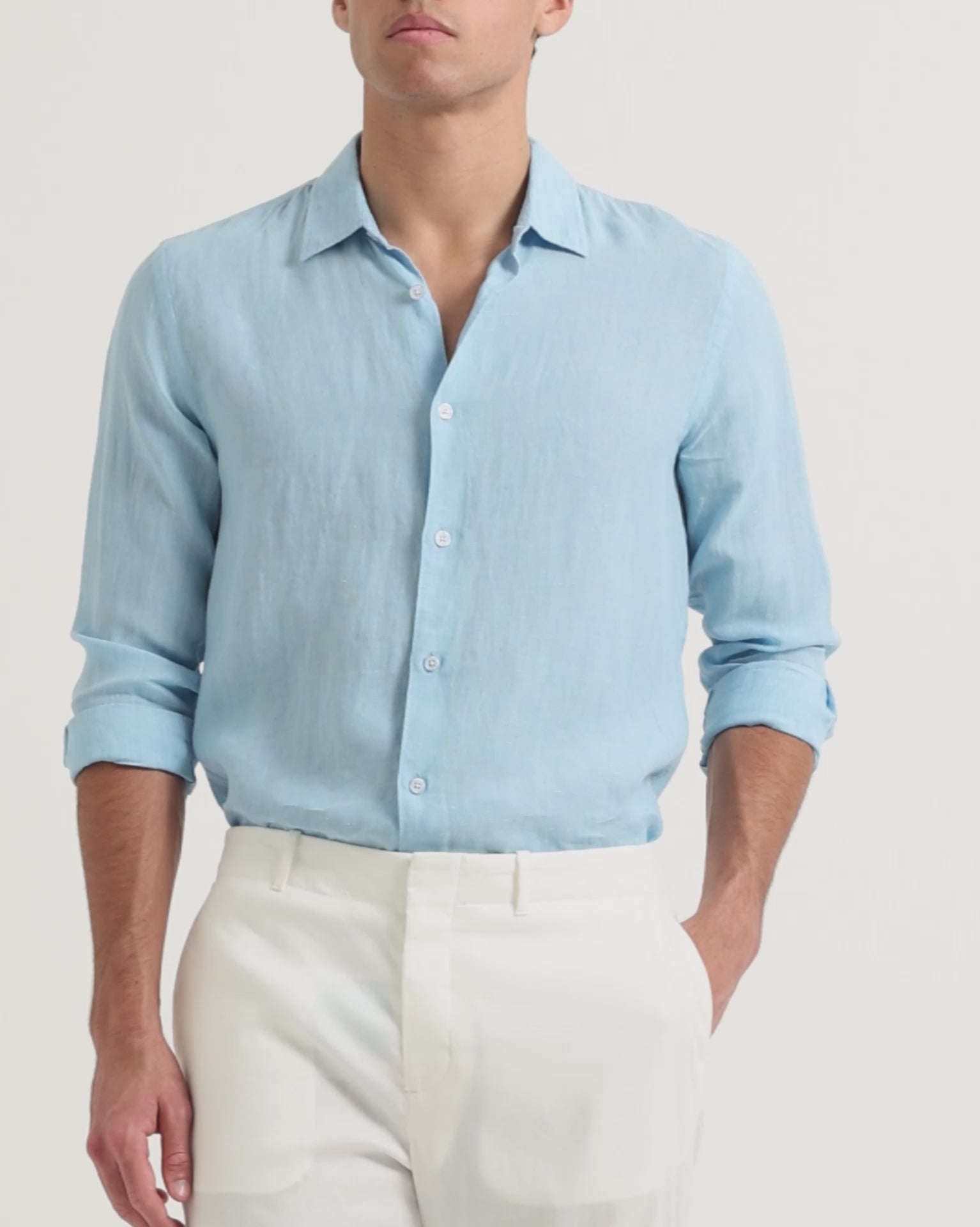 Man wearing light blue linen shirt with white trousers
