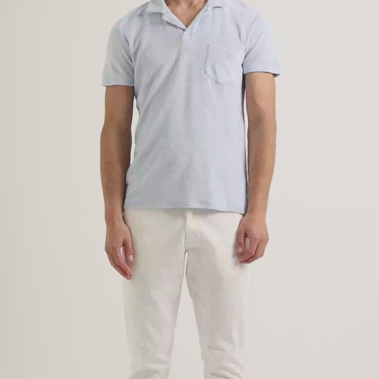 Light blue terry towelling polo shirt with white trousers