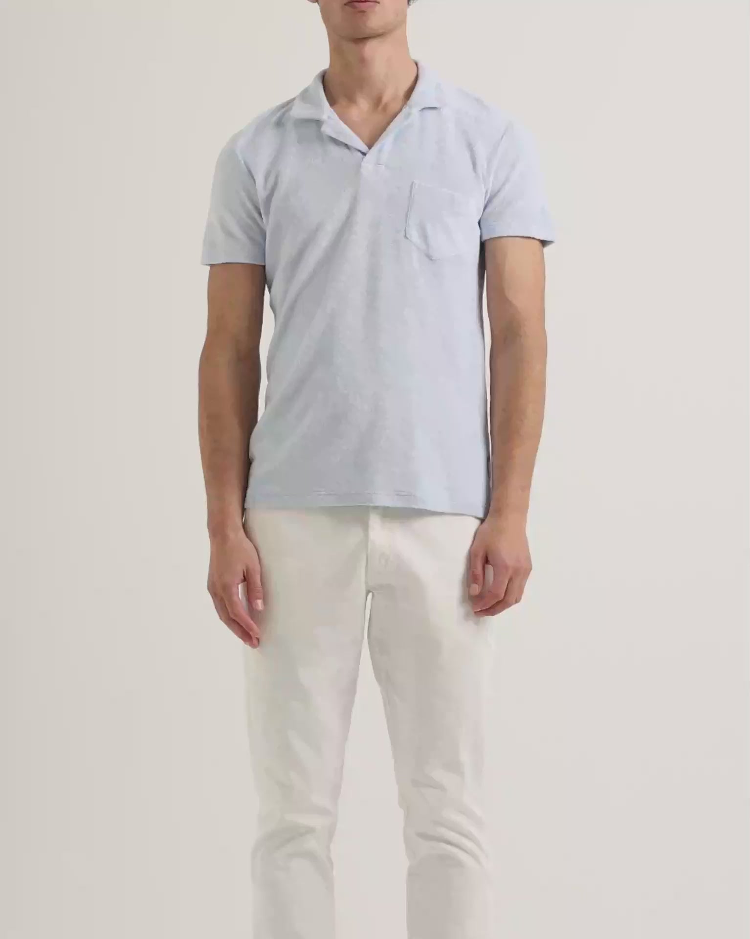 Light blue terry towelling polo shirt with white trousers