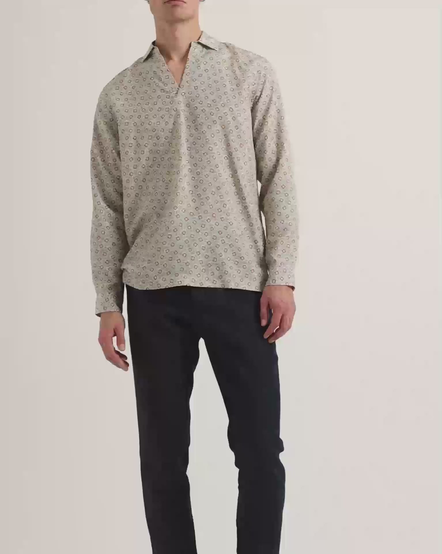 Man wearing patterned long sleeve shirt with dark navy trousers
