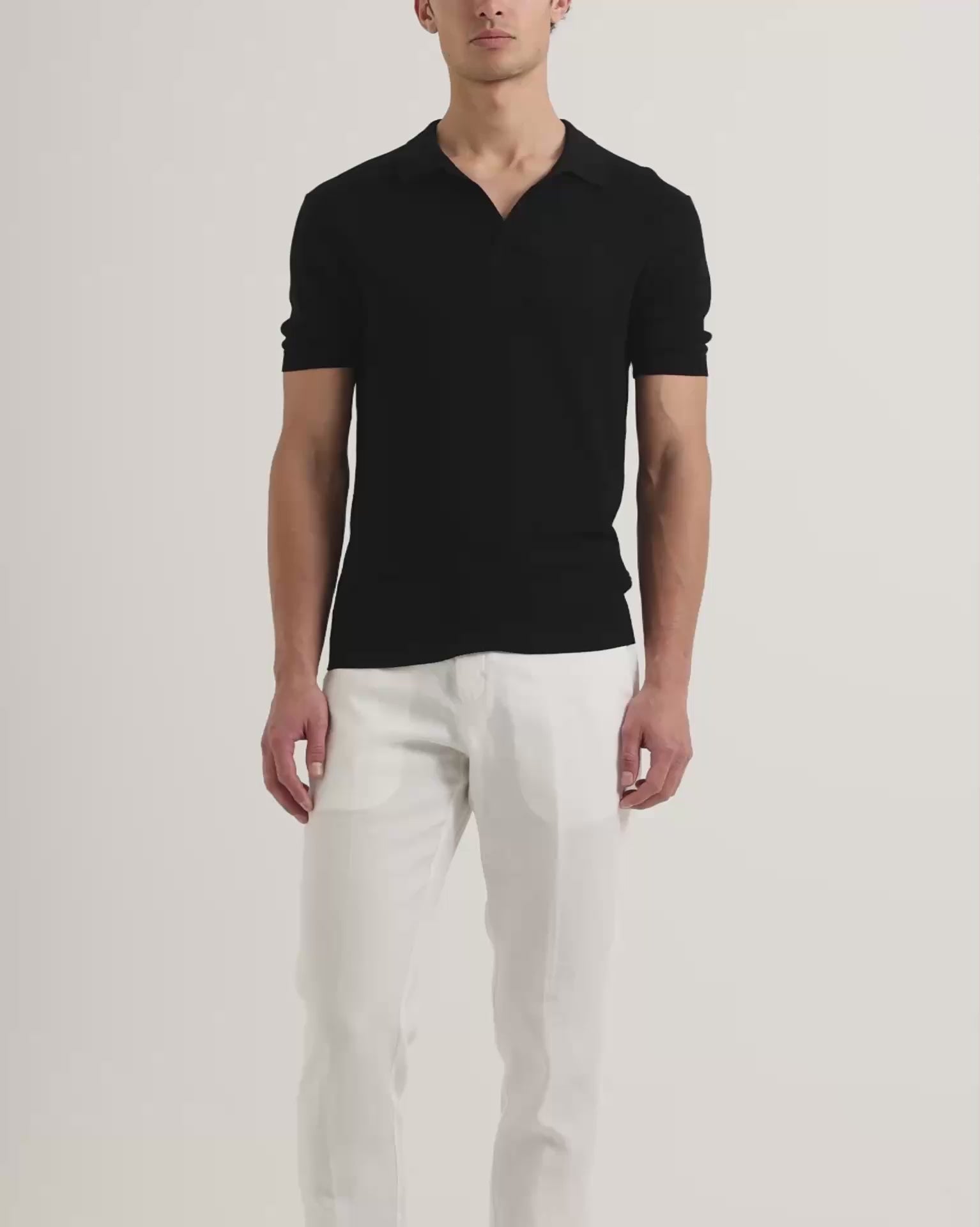 Man wearing black polo shirt with white trousers