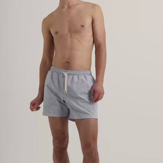 Man wearing blue striped swim shorts with drawstring waist