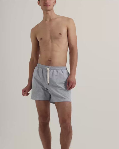 Man wearing blue striped swim shorts with drawstring waist