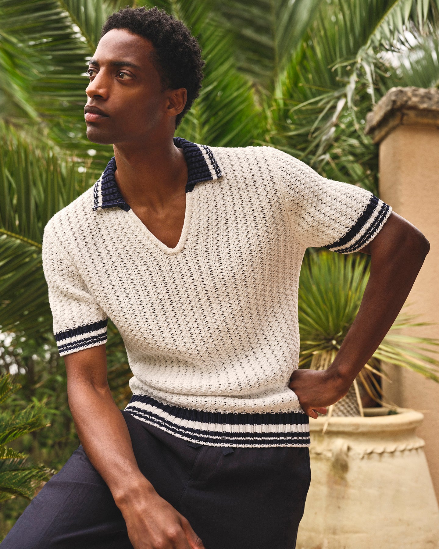 Man wearing a white knitted sweater with navy accents outdoors